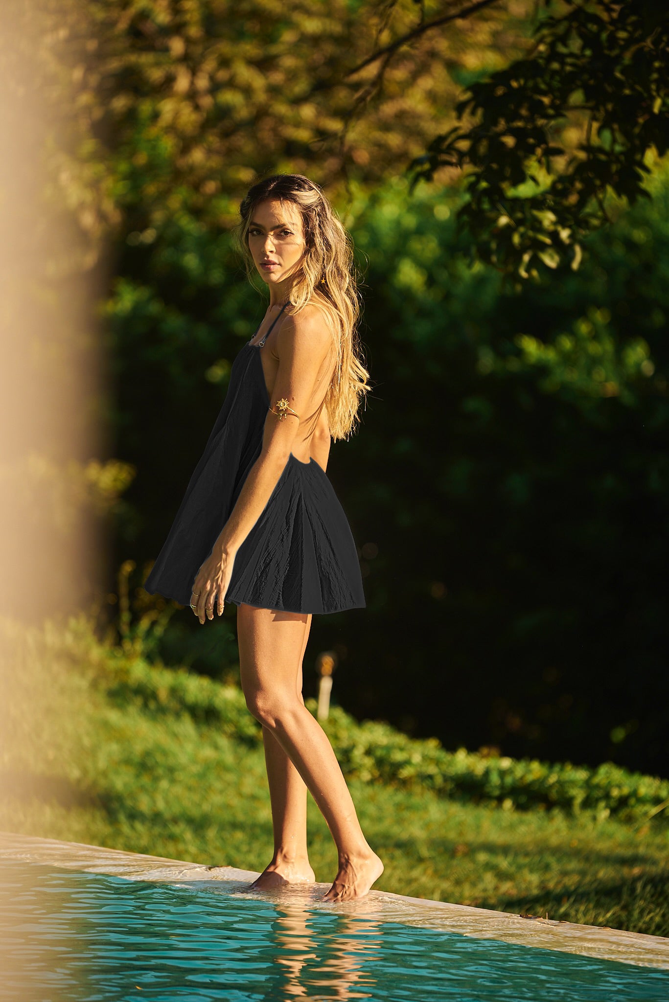 Model by the pool wearing Lonarc Black's cotton dress